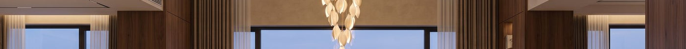 Large cascade chandelier in a double-height villa hall with tall glazing